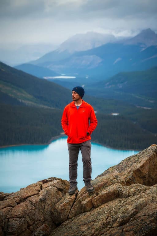Justin Leveillee standing above a mountain lake